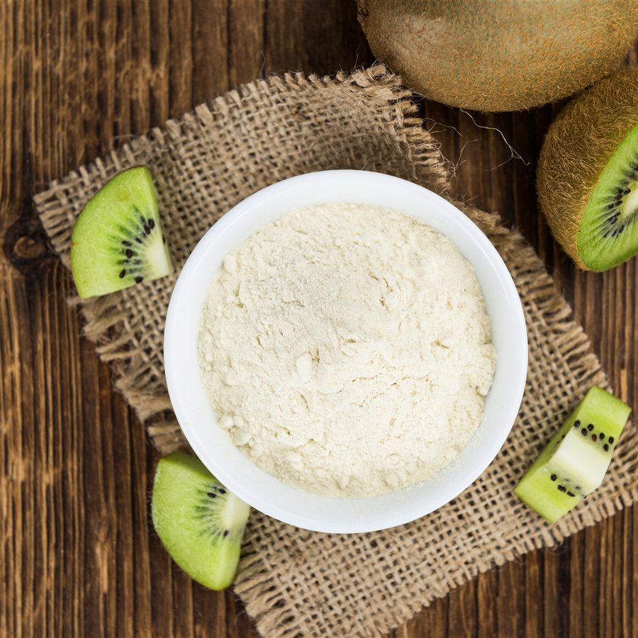 Freeze-dried kiwi powder and fresh kiwifruit Bowl of freeze-dried green kiwifruit powder beside fresh kiwifruit slices